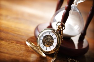 Hour glass or sand timer with vintage pocket watch, symbols of time with copy space